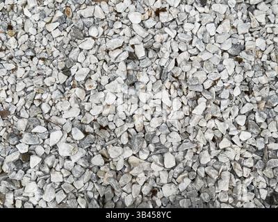 Background of white and grey pebbles and small stones scattered in an even layer on the floor, top view Stock Photo