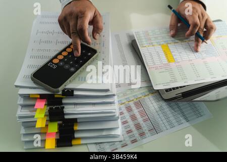 man accountant working on desk using calculator calculate while working analytic Accounting Stock Photo