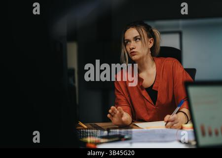 Focused woman analyzing business strategy during late evening meeting Stock Photo