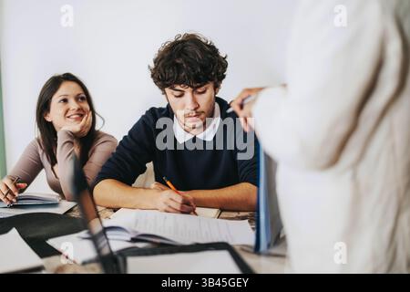 High school students collaborating with teacher on assignments at home Stock Photo
