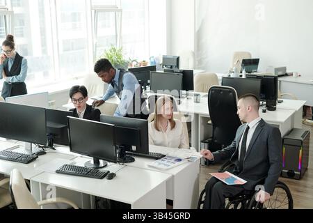 Two small groups of intercultural office managers working in teams Stock Photo