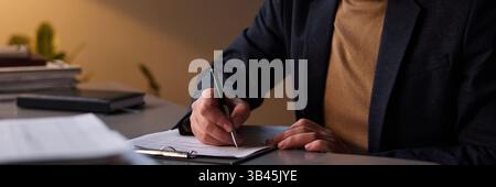Header of male counselor in smart casual attire analyzing symptoms of patient and taking notes on paper document Stock Photo