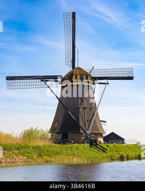 Historic windmill beside a calm canal in Kinderdijk, Netherlands ...
