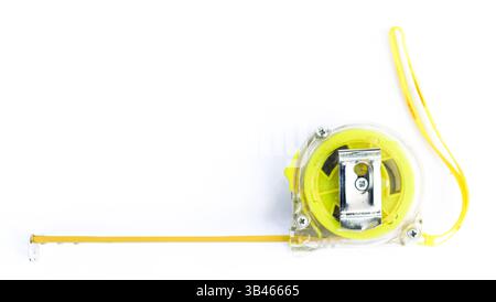 An eye-level close-up shows a yellow retractable tape measure against a bright white surface, showcasing detail, precision, and tool. Stock Photo