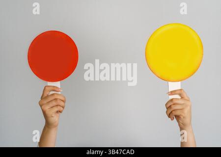 Female hand holding blank mock up banner sign as copy space for quotation text or graphic design. Sign red circle and yellow circle in female hand on Stock Photo