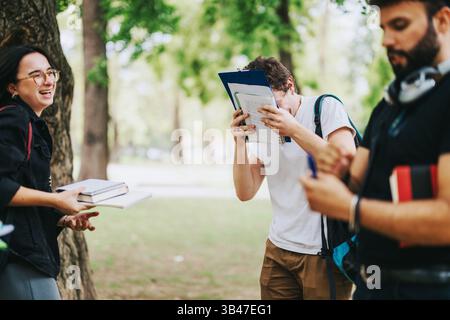 Multicultural students collaborating on school projects in park Stock Photo
