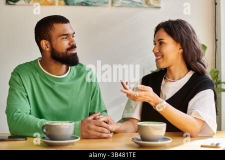An African American couple enjoys a warm conversation over coffee in a charming cafe. Stock Photo