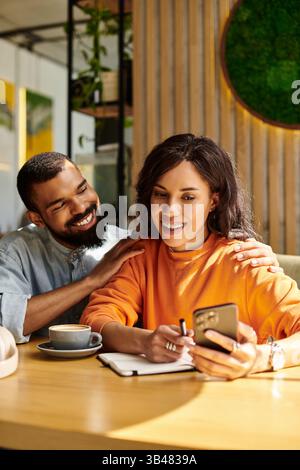 A couple enjoys their time together, laughing and sharing moments over coffee in a sunny cafe. Stock Photo