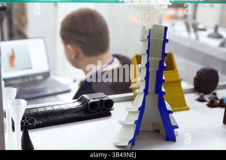 A man working behind a laptop in the 3D printing laboratory. Industry Stock Photo