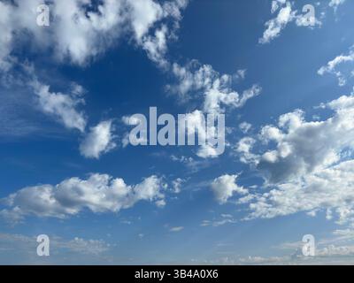 Stunning blue sky filled with white fluffy clouds on a bright, sunny day. Stock Photo