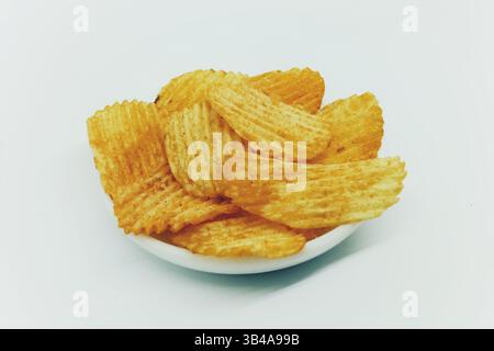 Textured thinly sliced potato chips snack with seasoning sprinkles isolated on white. Stock Photo