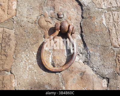 A rusty mooring ring attached to a weathered stone surface, Scotland Stock Photo