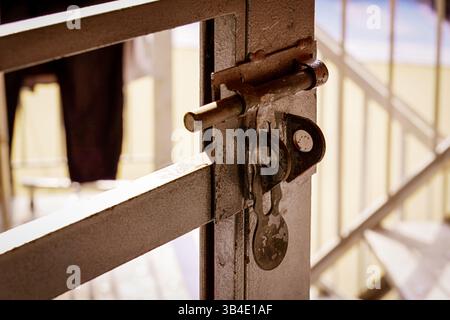 A rusty bolt lock on a metal gate in soft light Stock Photo