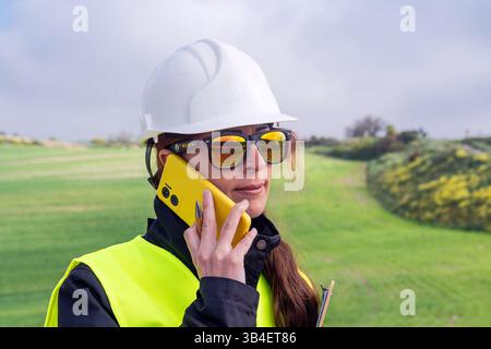 Female engineer using smartphone on renewable energy site Stock Photo
