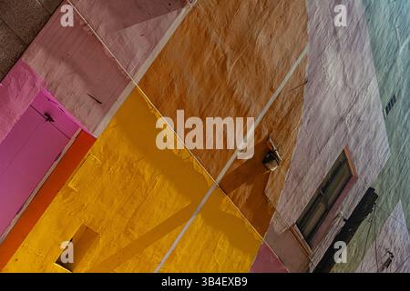 Reflected sheen on a rendered painted wall in a Vancouver alleyway Stock Photo