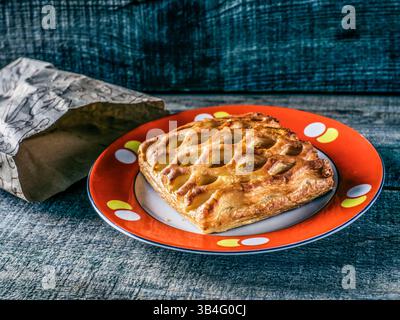 Oct. 11, 2015 - Cake from flaky pastry with apricot jam on the old plate with red border on vintage weathered wooden background (Credit Image: © Igor Goiovniov via ZUMA Wire) Stock Photo