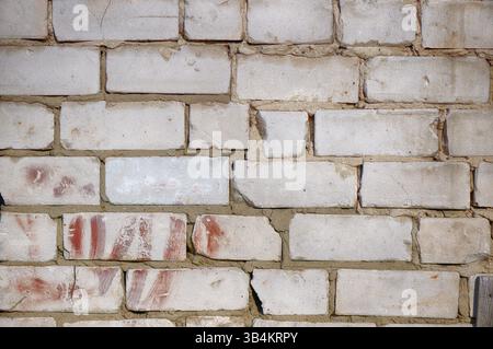 Abstract brick wall texture for the background. Roughly laid brick wall made of old cracked bricks Stock Photo