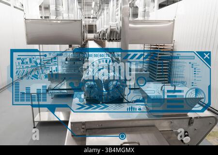 Industrial production line equipment with a futuristic blue digital HUD overlay displaying data and system monitoring Stock Photo