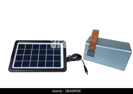 A portable solar panel connected to a large power bank, providing off grid renewable energy on a white background Stock Photo