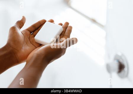 Unrecognizable Black Man Washing Hands Holding Antibacterial Soap In Bathroom Stock Photo