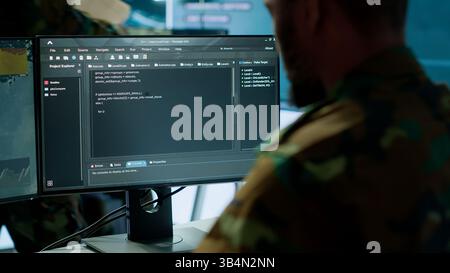 Military specialist in a high tech control center managing satellite radar surveillance, collecting intelligence on cctv systems. Interpreting real time data to ensure national defense. Camera A. Stock Photo