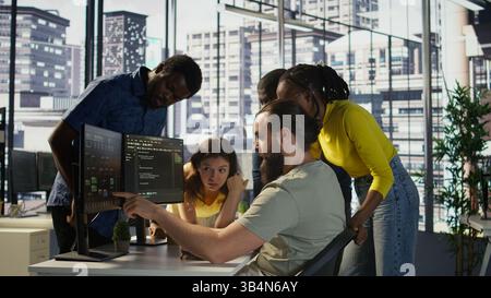 Team of software engineers doing brainstorming to create machine learning models that can process and analyze data to improve decision making processes. Colleagues working together in office, camera B Stock Photo
