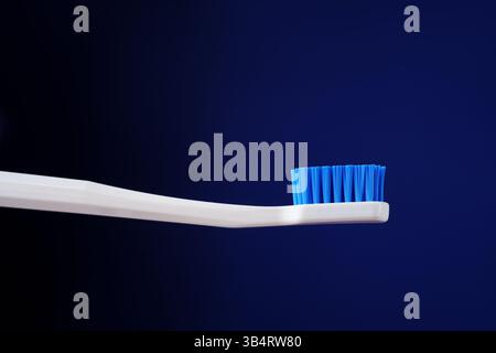 Dental king concept. Hygiene. Advertising banner. White toothbrush on a dark blue gradient background. Stock Photo