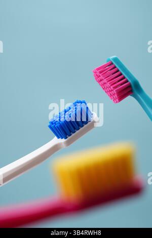 Advertising of oral hygiene. Three toothbrushes on a blue background close-up. Stock Photo