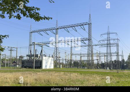 Substation with open-air switchgear for power distribution, in the background high electricity electricity electricity pylon with overhead power lines Stock Photo