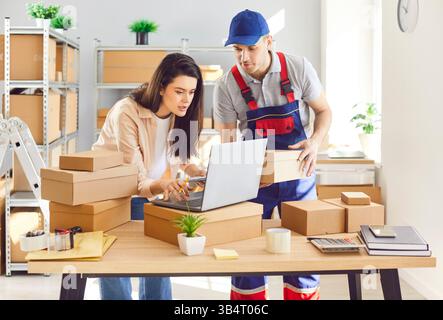 Man And Woman Working Together In Parcel Warehouse Stock Photo