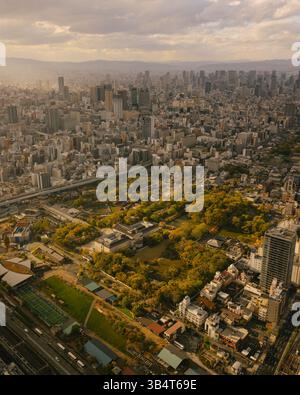 Aerial view of Osaka cityscape during a stormy dramatic sunset showing highways towers and dense residential districts Stock Photo