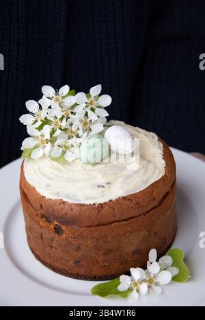 Enjoy a beautifully crafted homemade Easter cake topped with creamy frosting, colorful Easter eggs, and fresh spring blossoms Stock Photo