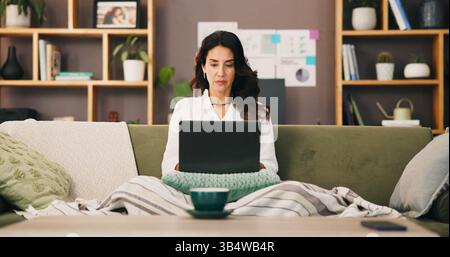 Laptop, remote work and woman on sofa for typing email, reading or serious financial analyst with project. Computer, living room and freelancer Stock Photo