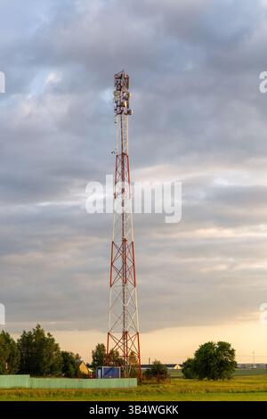 Sunset over rural farmland with cell tower, symbolizing communication, technology, and connectivity. Stock Photo