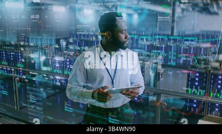 Futuristic Big Data Center with VFX: African American Administrator Using Digital Tablet. Animated Diagrams of Internet Traffic on Servers. Information Technology, Digitalization Concept. Medium Shot. Stock Photo