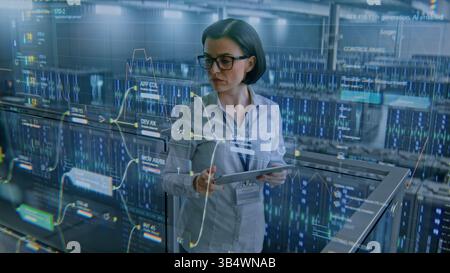 Futuristic Big Data Center with VFX: Female Specialist Using Tablet Computer. Animated Charts of Cloud Computing and Internet Traffic on Servers. Information Technology, Digitalization. Medium Shot. Stock Photo