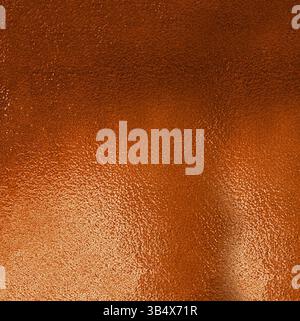 Orange metallic background reflecting light creating a gradient effect Stock Photo