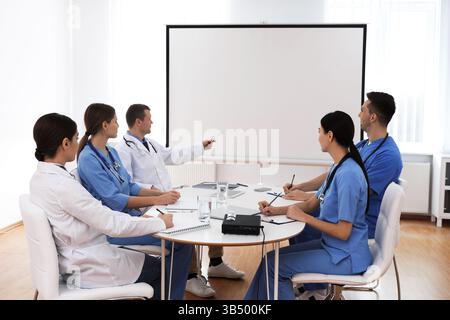 Team of doctors using video projector during conference indoors Stock Photo