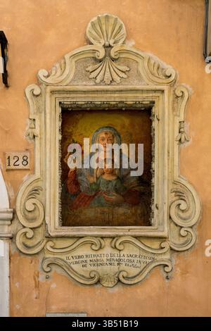 A street aedicula featuring a fresco of the Madonna and Child, located at Via Garibaldi 128 in Foligno, Italy. Stock Photo