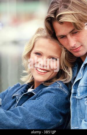 Young couple sitting outdoors close up by marina,. Stock Photo
