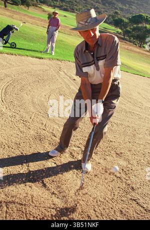 Senior man & woman playing golf. Stock Photo