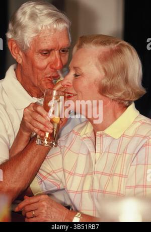 Senior man & woman drinking cocktails indoors. Stock Photo