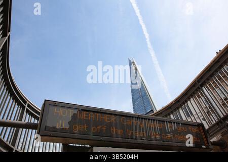 London, UK. 1st May, 2025. As a mini heatwave peaks with temperatures of 29 degrees in London, the entrance to London Bridge underground station, in the shadow of the Shard, carries a warning notice to passengers to carry water and stay hydrated during their journeys. Credit: Anna Watson/Alamy Live News Stock Photo