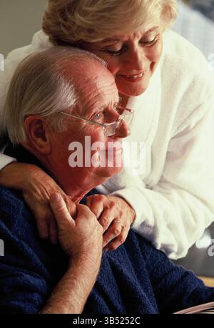 Senior man & woman couple in bathrobes indoors at home. Stock Photo