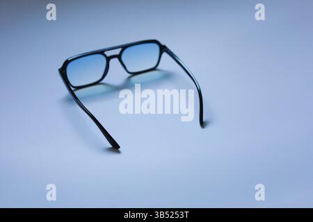 A stylish pair of modern glasses displayed in a minimalist setting. Sleek design and high-quality frames highlight fashion and functionality. Perfect Stock Photo