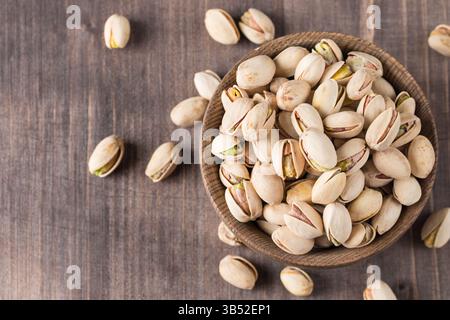 Organic roasted pistachio nuts in a wooden bowl. Top view. Stock Photo