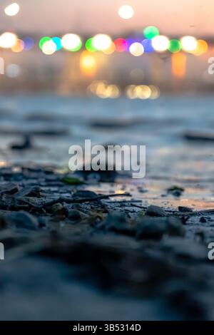 Colorful bokeh lights reflected on a riverbank surface Stock Photo