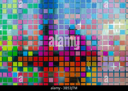 Mosaic of small multi-colored squares on glass, close-up. Matrix style multicolored digital squares. Stock Photo