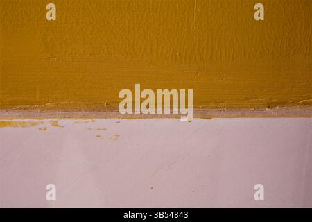 Detailed view of a wall showing rough yellow and white paint textures Stock Photo