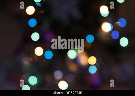 Blurry multicolored lights in soft focus on a dark background. Abstract bokeh effect creating a beautiful festive and dreamy atmosphere Stock Photo